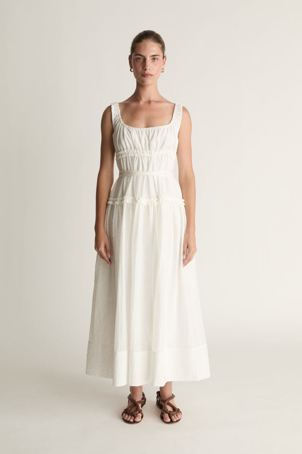 Woman wearing a white dress against a plain background