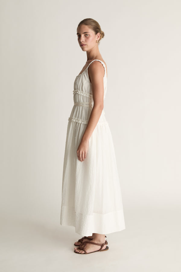 Woman wearing a white dress against a plain background