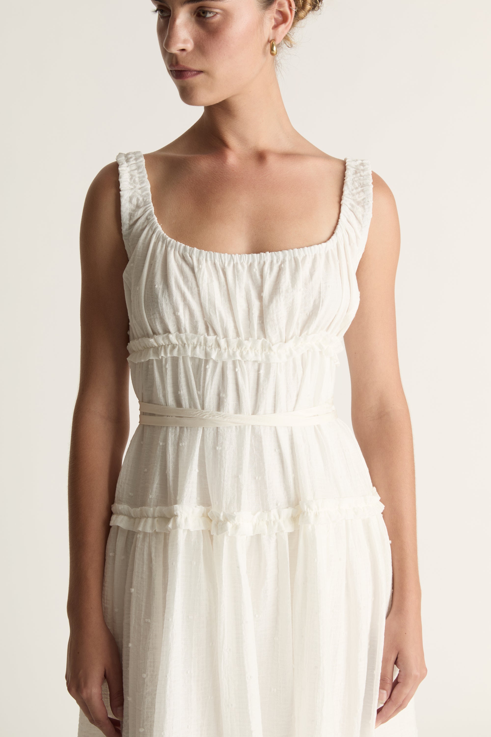 Woman wearing a white dress against a plain background