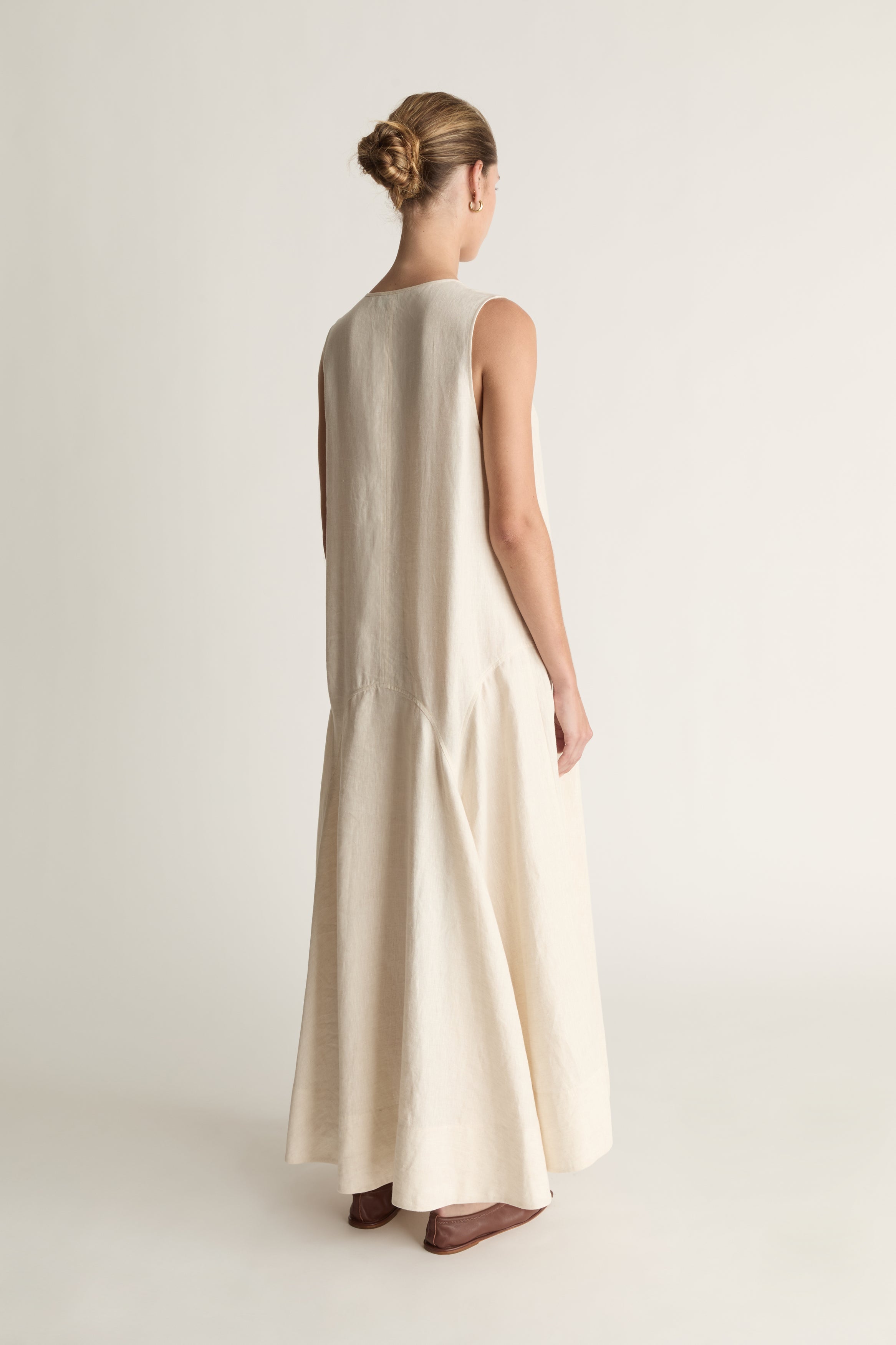 Woman wearing a long beige dress on a white background