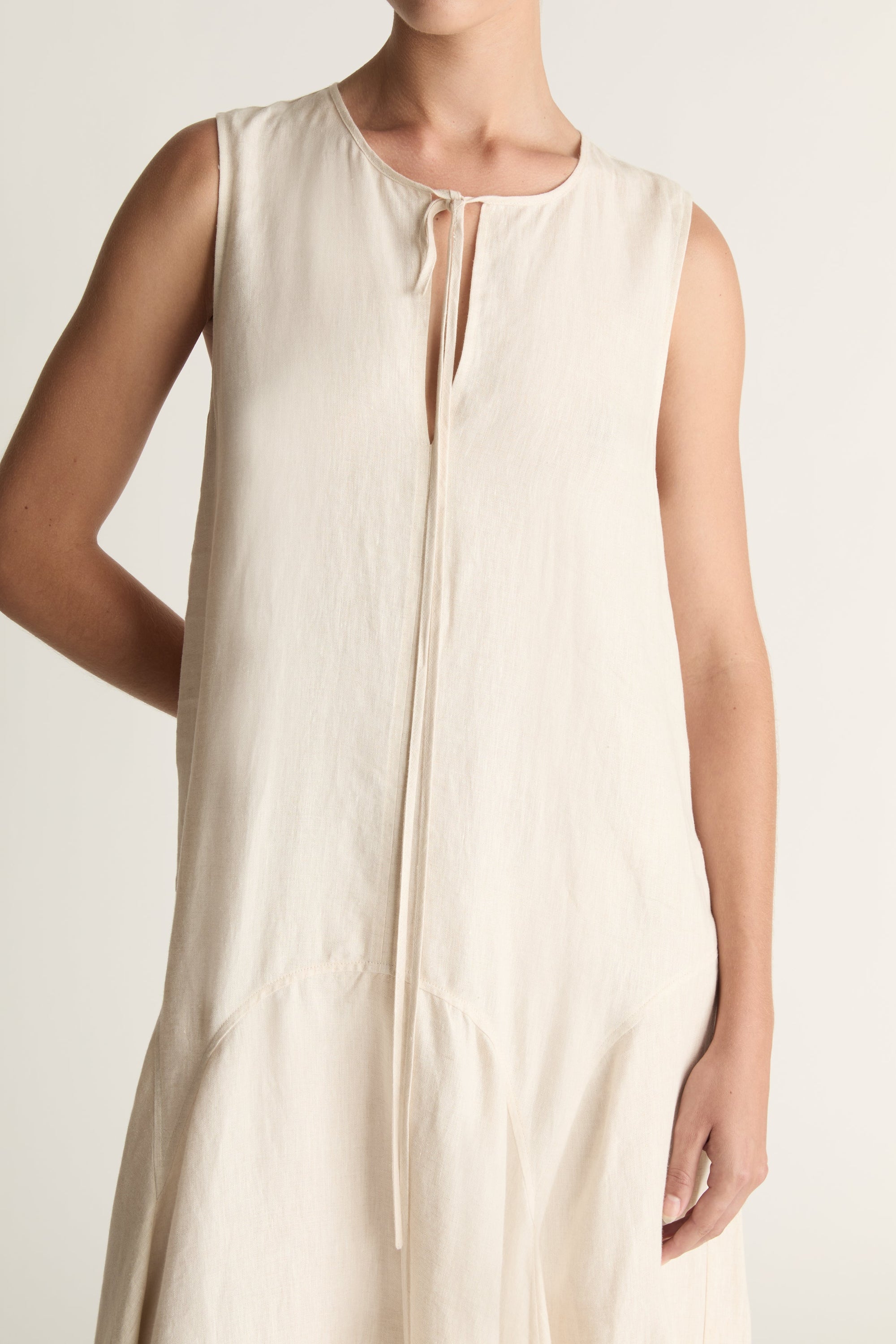 Woman wearing a long beige dress on a white background