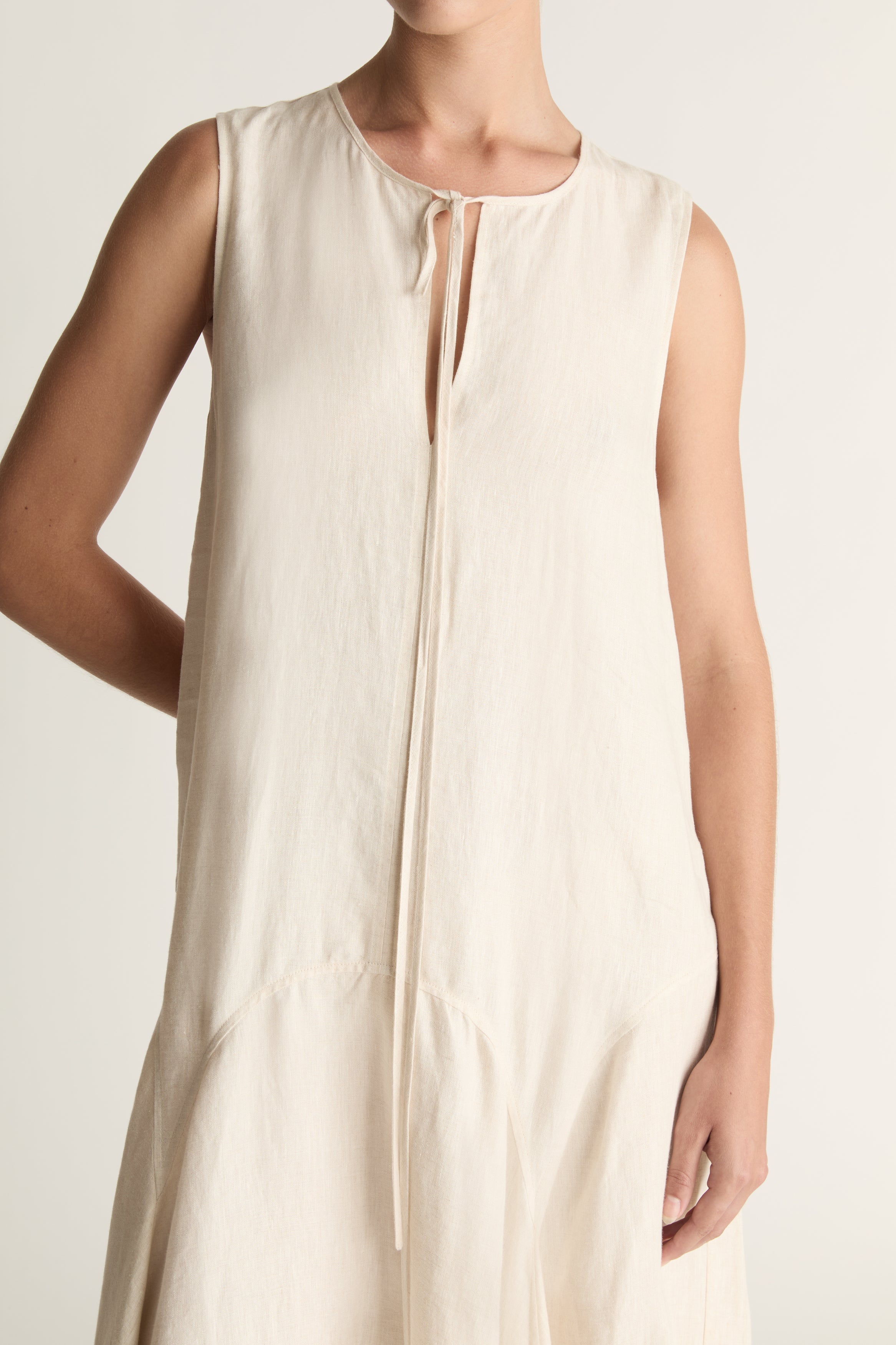 Woman wearing a long beige dress on a white background