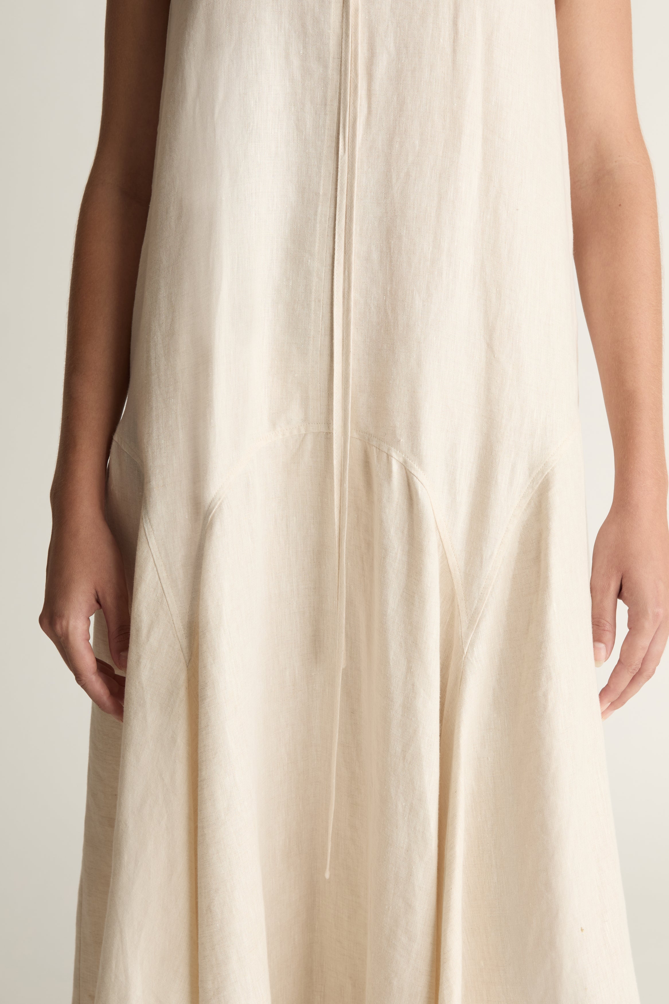 Woman wearing a long beige dress on a white background