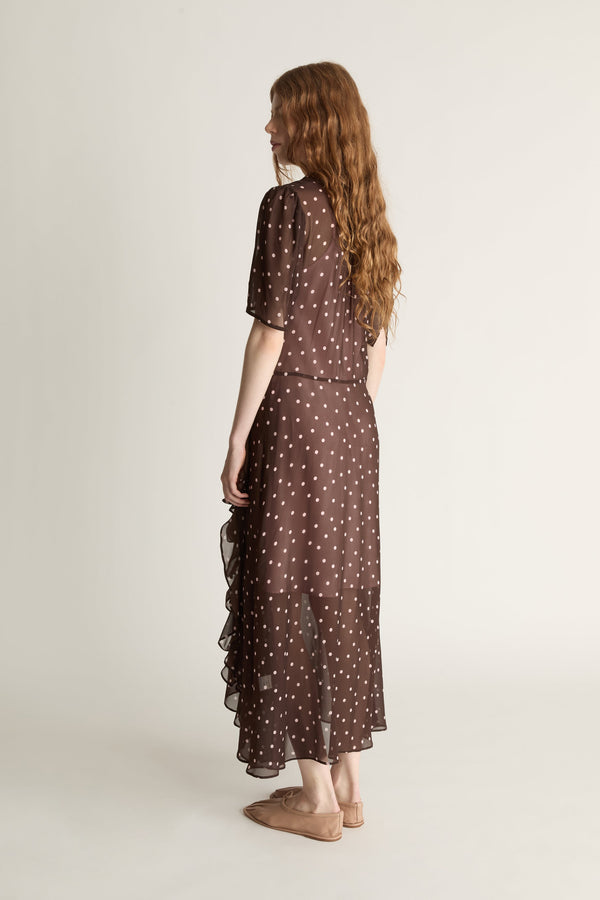 Woman wearing a brown polka dot dress on a white background