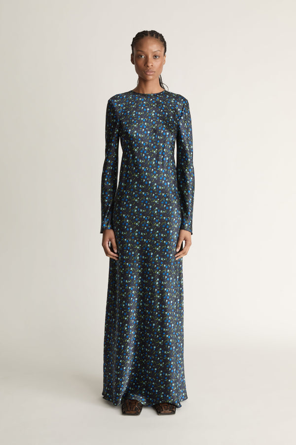 Woman wearing a long-sleeve dress with a pattern on a white background