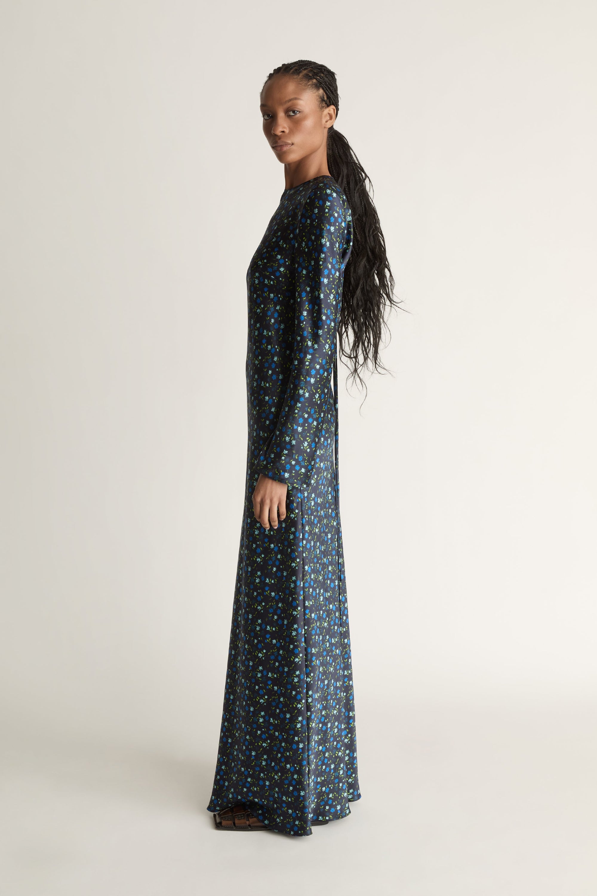 Woman wearing a long-sleeve dress with a pattern on a white background