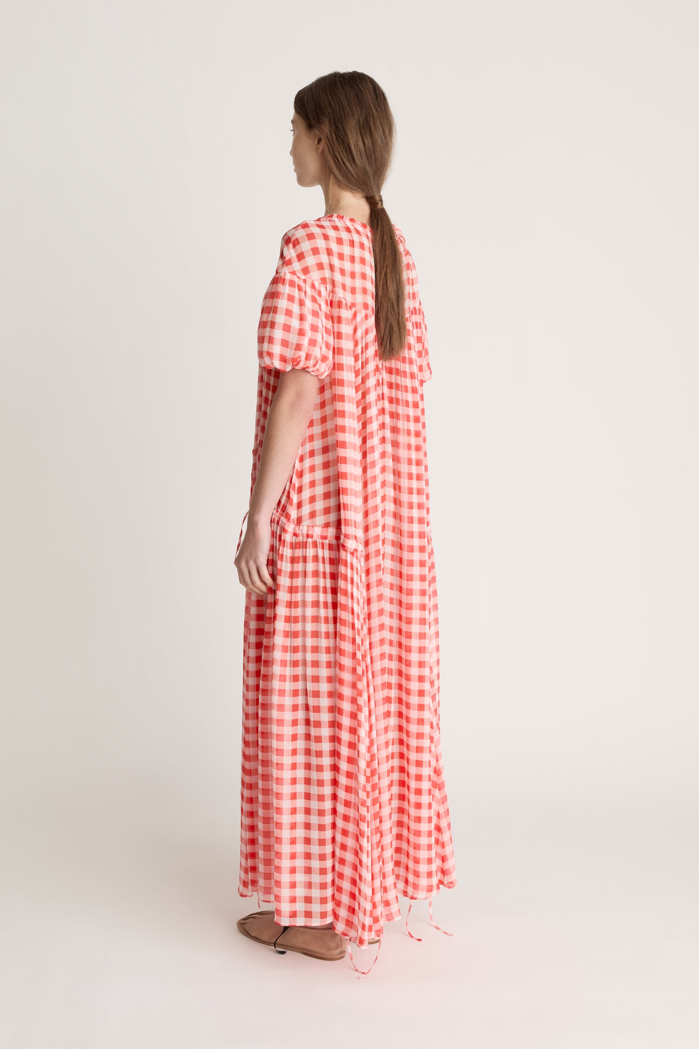 Woman wearing a red and white checkered dress on a white background