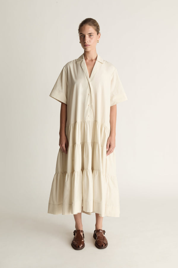 Woman wearing a beige dress against a white background