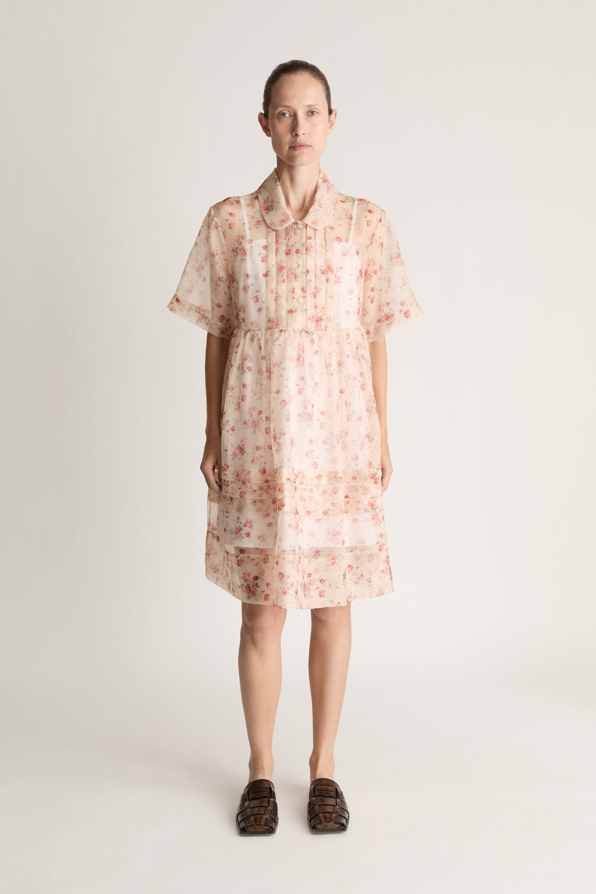 Woman wearing a floral mini dress on a white background