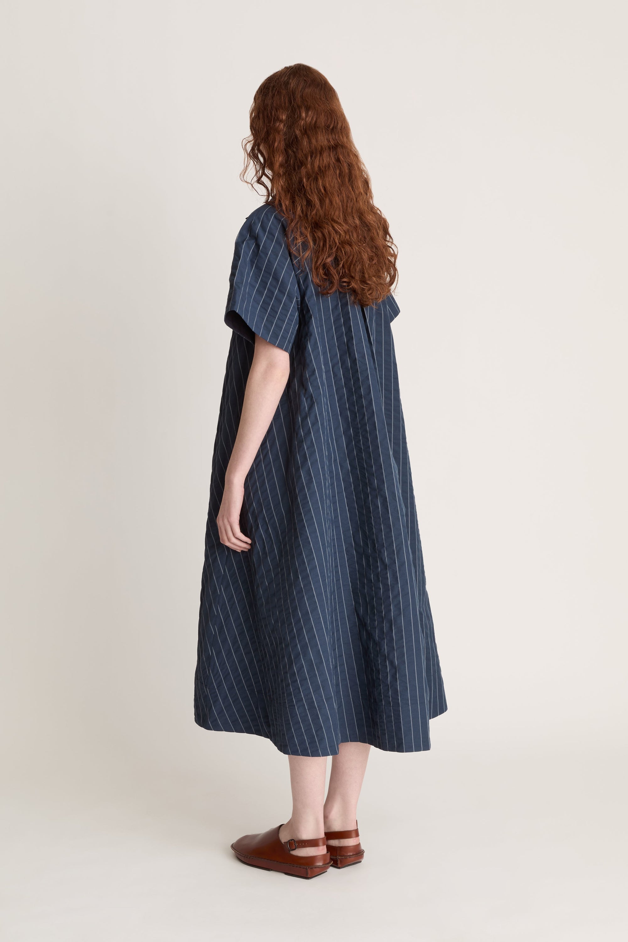 Woman wearing a blue striped dress on a white background