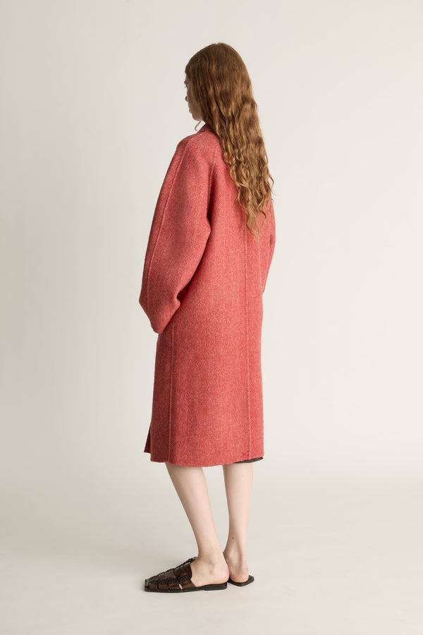 Person wearing a red coat on a plain background