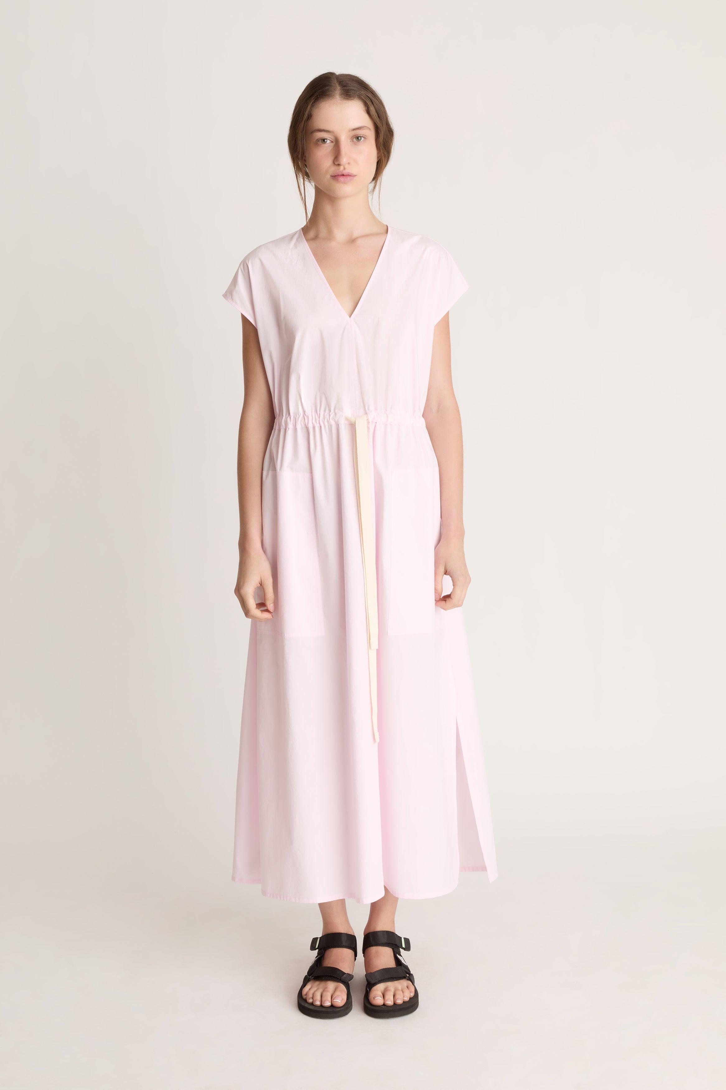 Woman wearing a light pink dress on a white background