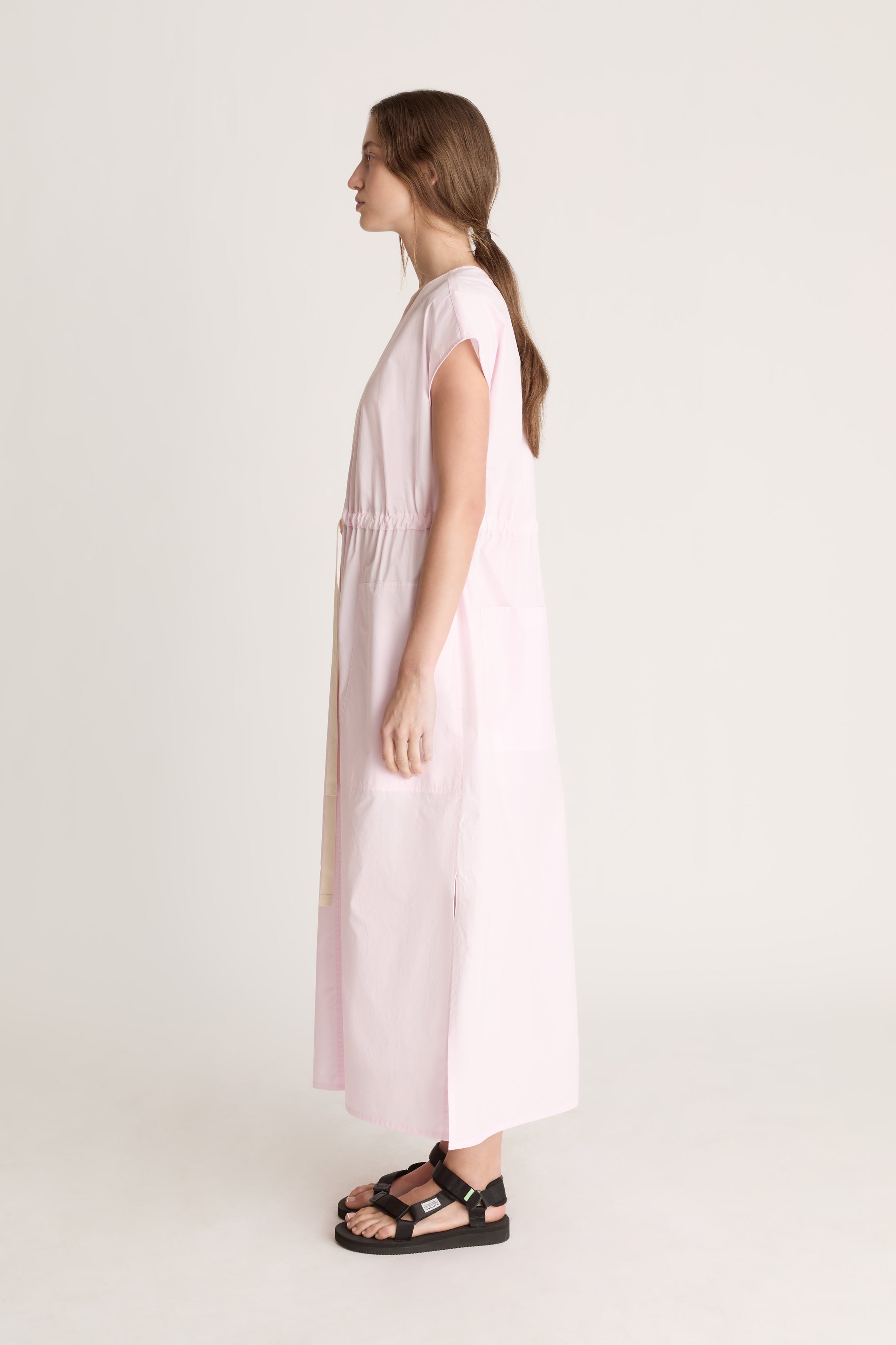 Woman wearing a light pink dress on a white background