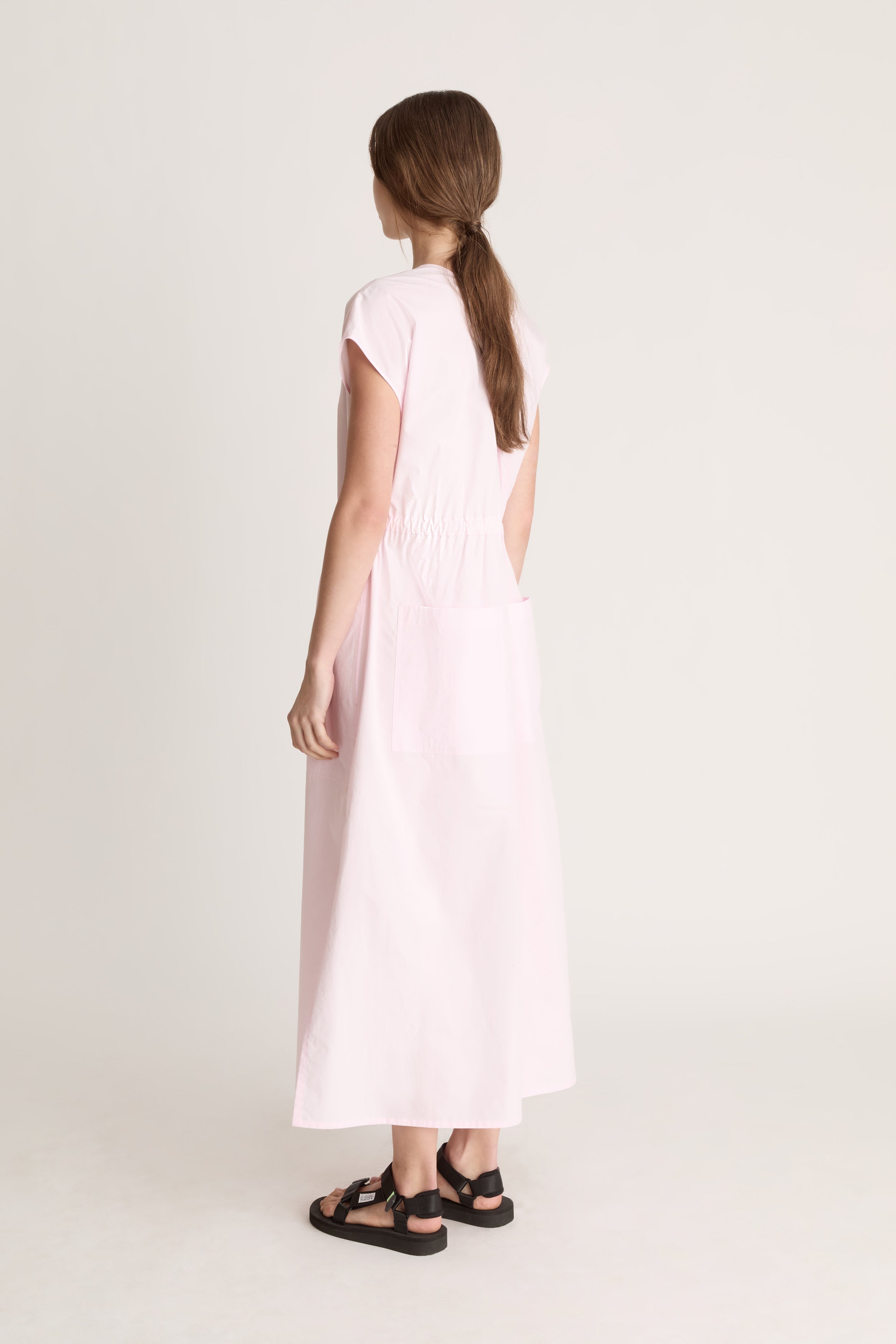 Woman wearing a light pink dress on a white background