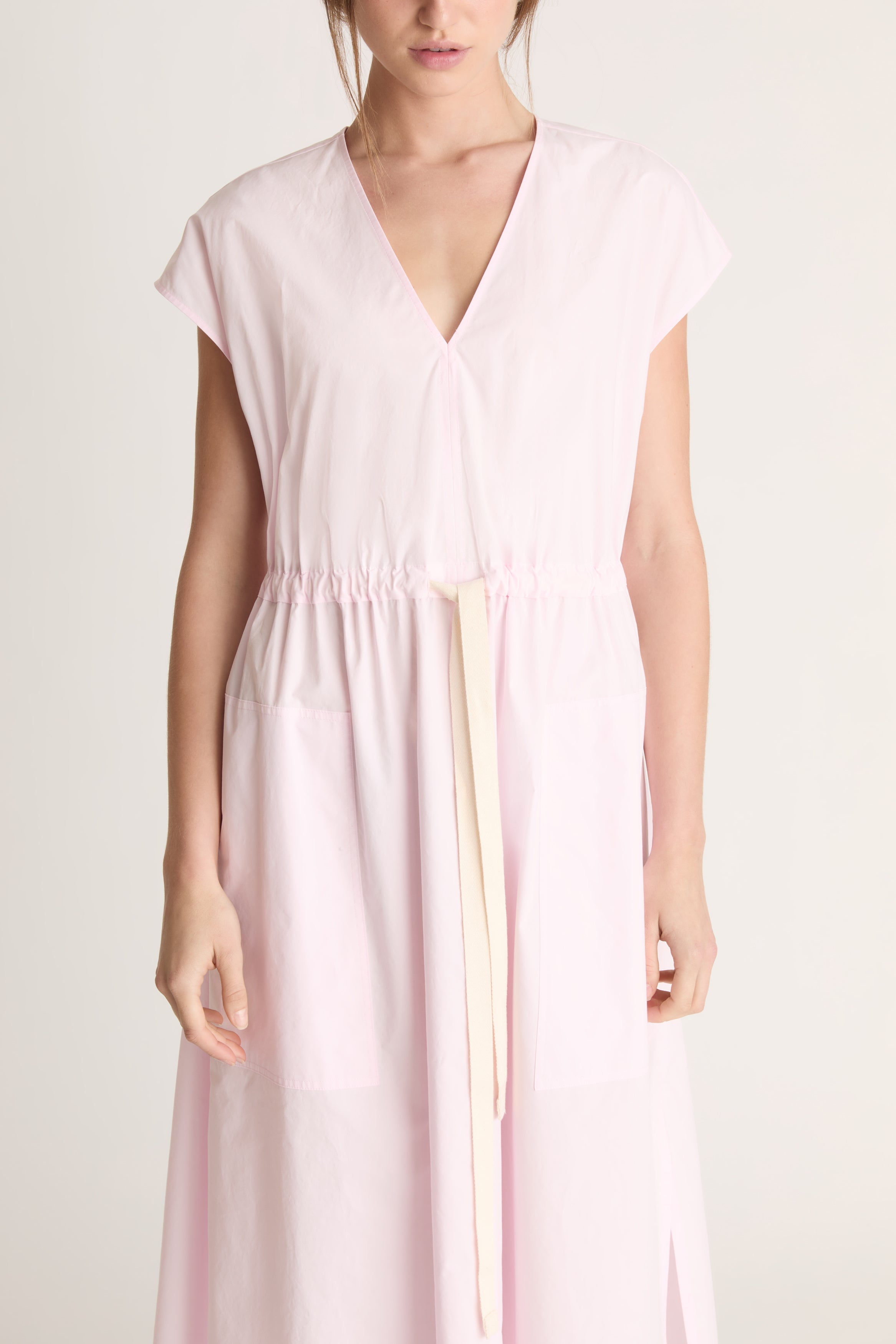 Woman wearing a light pink dress on a white background