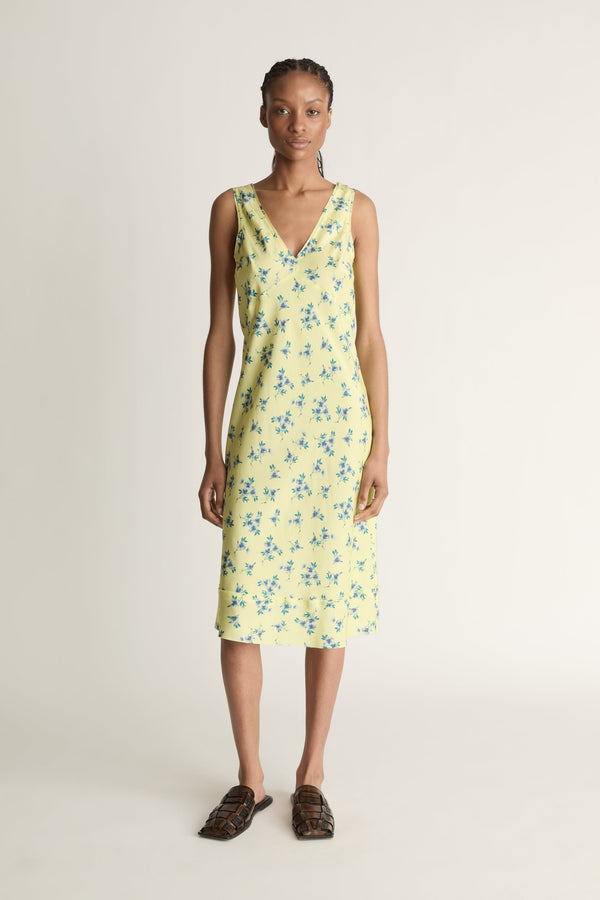 Woman wearing a yellow floral dress on a white background