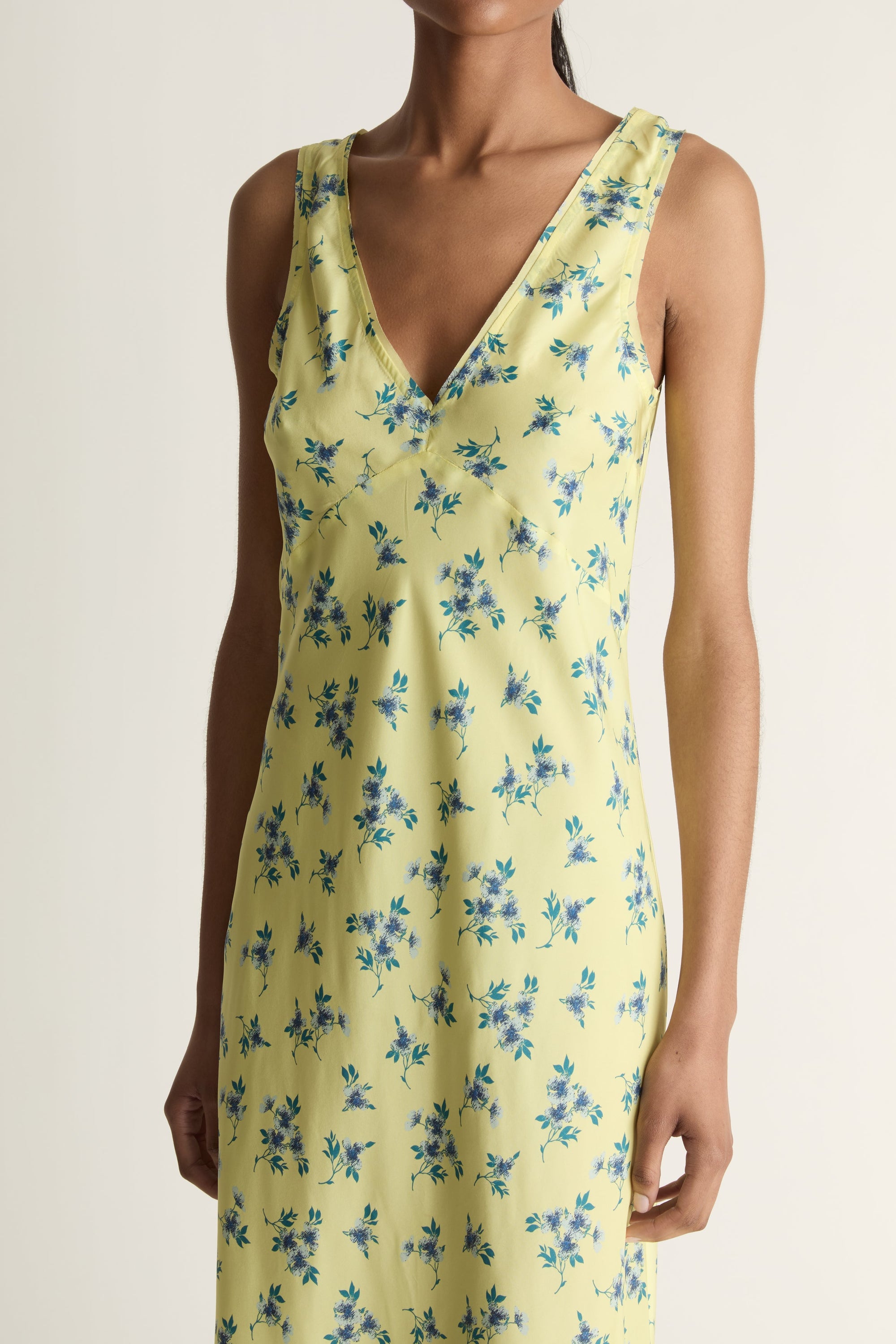 Woman wearing a yellow floral dress on a white background