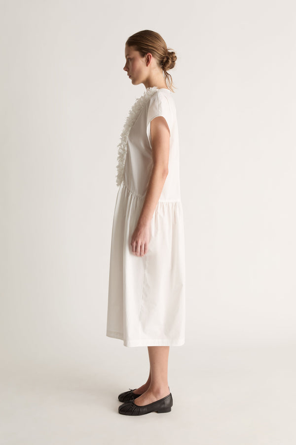 Side view of a white midi dress with cap sleeves, a ruffled front and gathered skirt.