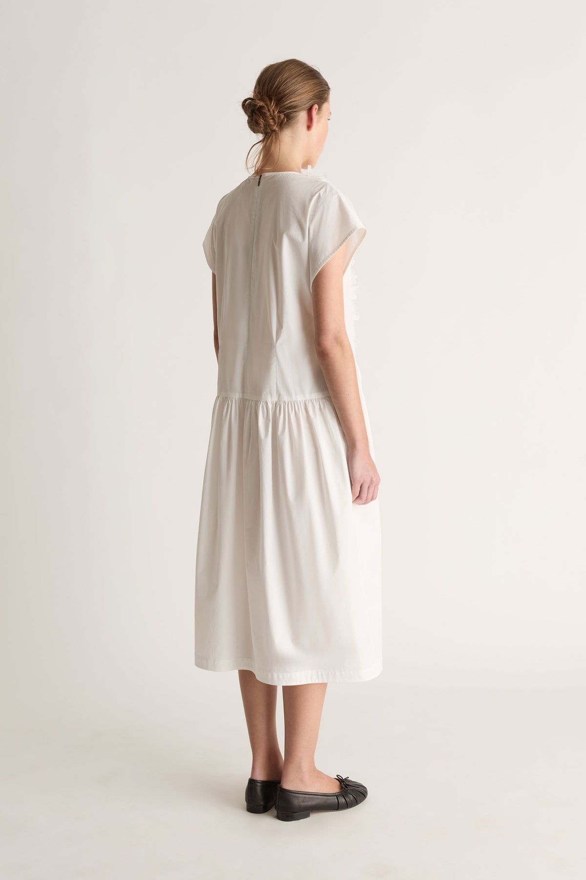 Back view of a white midi dress with cap sleeves, a back neck opening and gathered skirt.