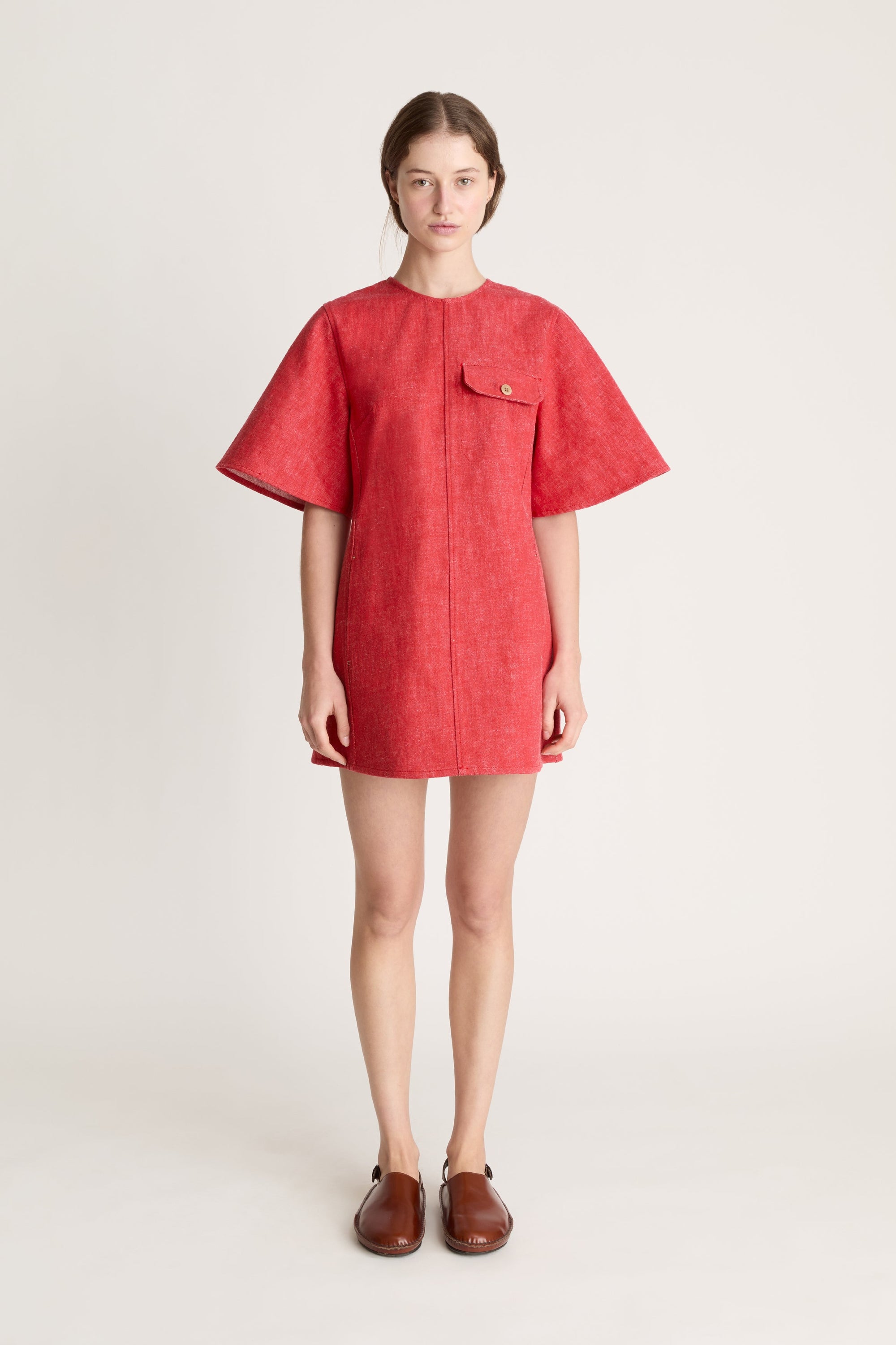 Person wearing a reddress and red pants on a white background