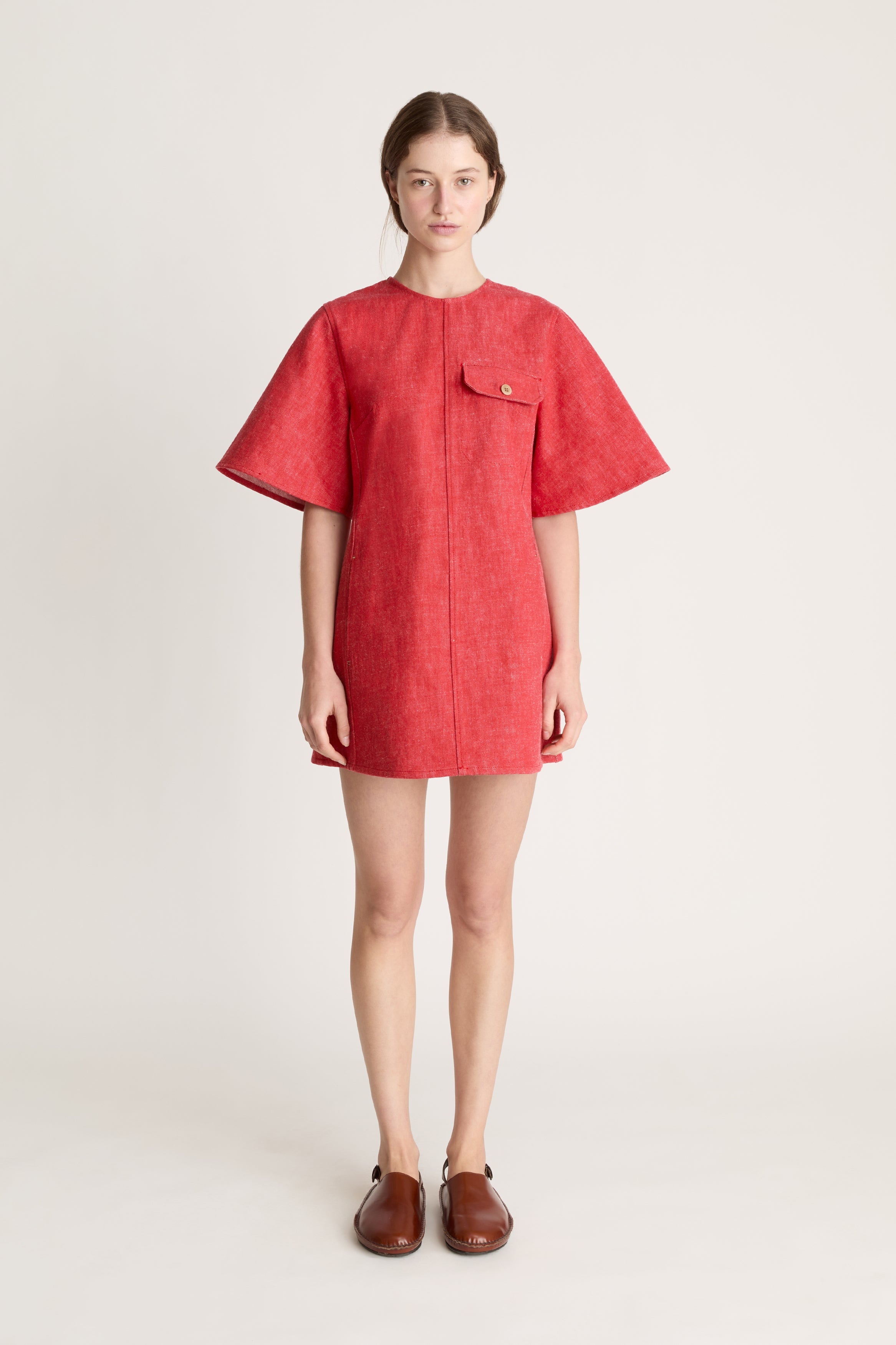 Person wearing a reddress and red pants on a white background