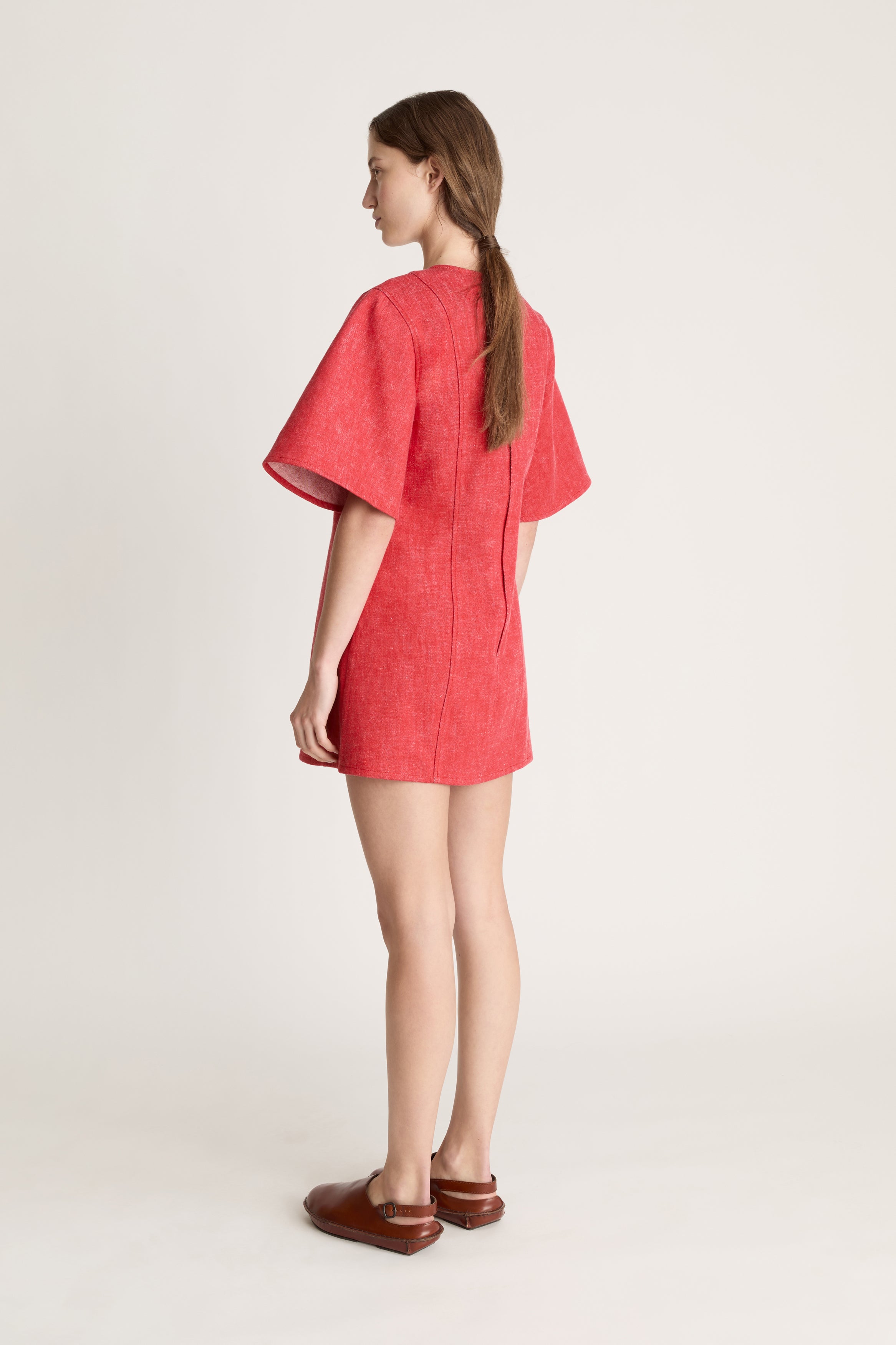 Person wearing a reddress and red pants on a white background