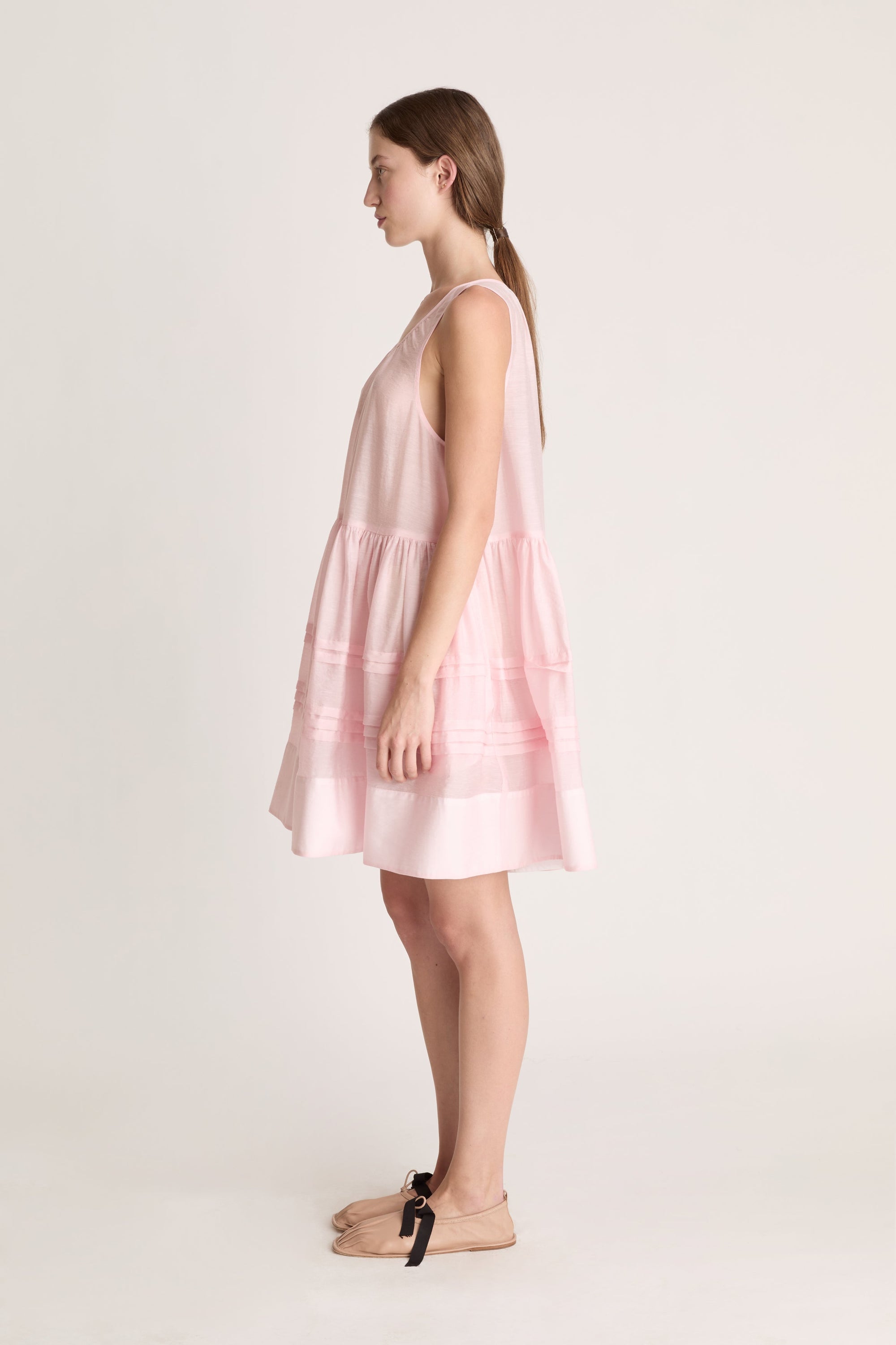 Woman wearing a pink dress against a white background