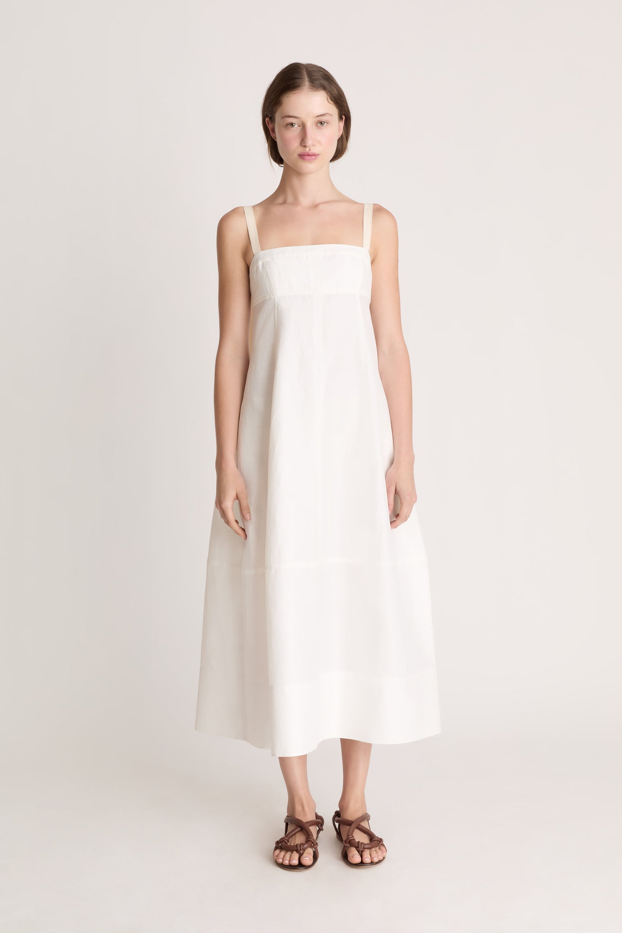 Woman wearing a white dress on a plain background