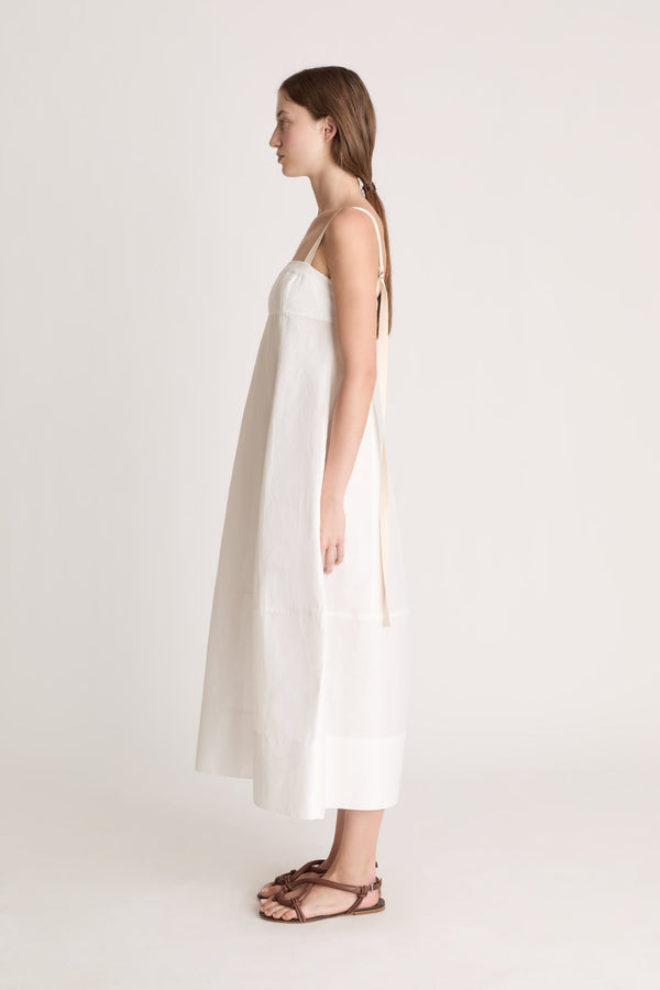 Woman wearing a white dress on a plain background