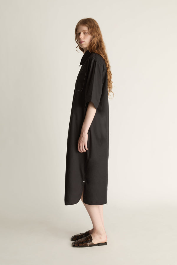 Woman wearing a black dress on a plain background