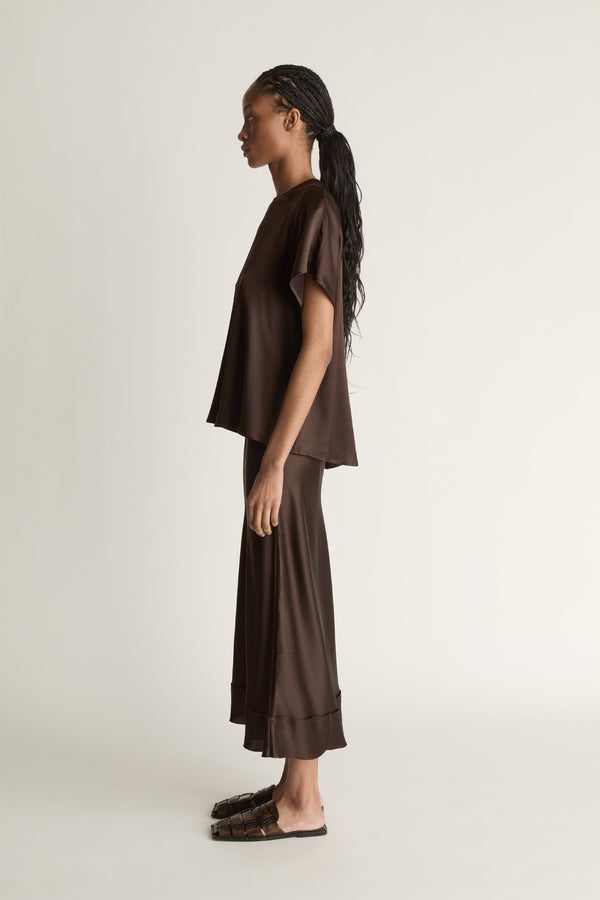 Woman wearing a brown outfit on a plain background