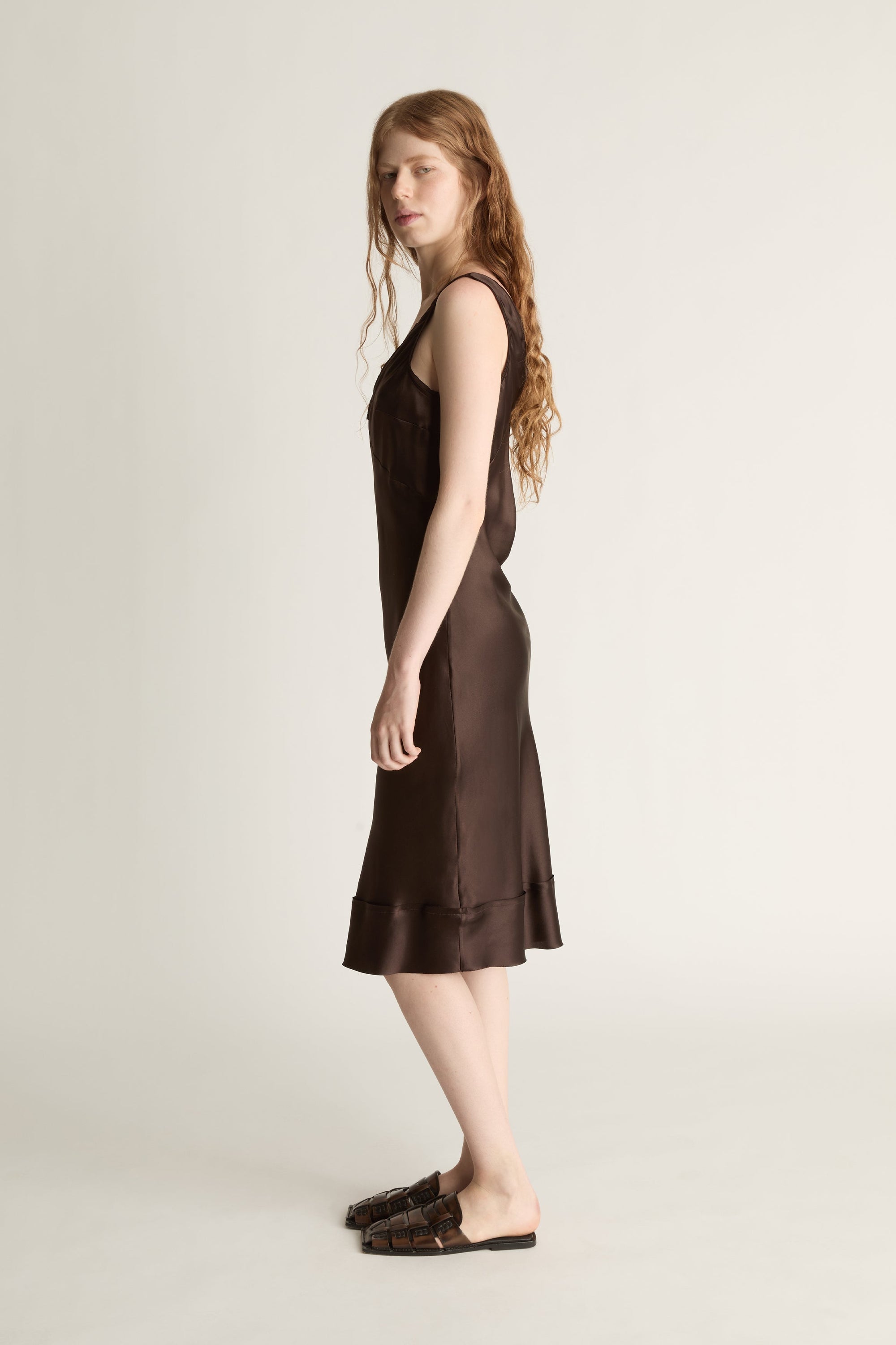 Woman wearing a brown dress on a plain background