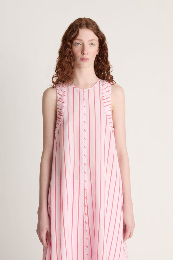 Woman wearing a pink and white striped dress against a plain background